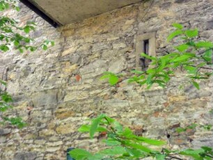 Stadtbefestigung-Ansicht im Ostnordosten-Stadtmauer über Feldseite als Gebäudeaußenwand-erhaltene Schlüsselloch-Schießscharte im Detail