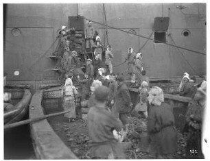 Nagasaki. Einheimische Frauen und Männer beladen den Hochseepassagierdampfer "Cleveland" über Ladeluken mit Kohle (transportiert in Körben)