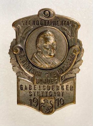 Ereignisabzeichen 9. Stenographentag des Deutschen Stenographenbundes Gabelsberger in Stuttgart 1910 (mit Broschennadel) : Medaillensammlung Stenografische Sammlung. Ereignisabzeichen 9. Stenographentag des Deutschen Stenographenbundes Gabelsberger in Stuttgart 1910 (Brustbild Gabelsbergers, Inschrift "9 Stenographentag d. Deutsch. Stenograph. Bundes Gabelsberger Stuttgart 1910" und Stadtwappen von Stuttgart, mit Broschennadel; rückseitig: Ad. Schwerdt Gravier-Präge und Galvanoplastische Anstalt Stuttgart). Metall; Maße 38 x 27 mm (1910; A. Schwerdt). Dresden: SLUB R c 0396