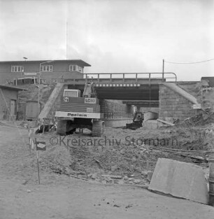 Pölitzer Weg: Bahnunterführung: Ausbau des Tunnels: Bagger beim Ausschachten vor und unter der Unterführung: vorn Erdhaufen, Steine und Absperrung: hinten links Stellwerk: 16. April 1972
