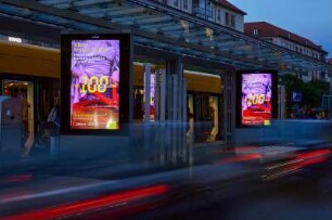 Citylight-Werbung zur Ausstellung "#BUNT. Erwin Fieger. Wolfgang G. Schröter. Reinhart Wolf" anlässlich von "100 Jahre Deutsche Fotothek" an der Straßenbahnhaltestelle Altmarkt, Dresden