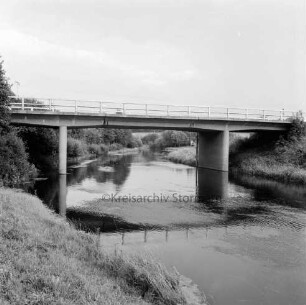 Trave: Brücke der Kreisstraße Richtung Bundesstraße B 75 bei Travenhof: rechts und links an Böschung Büsche und Bäume