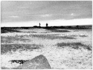 Zwei menschliche Figuren am Horizont, im Vordergrund eine Sand- und Grasfläche