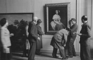 Eröffnung der Dauerausstellung in der Alten Nationalgalerie : Ludwig Justi, Direktor der Nationalgalerie, mit Aufbauhelfern beim Aufhängen des Gemäldes "Bildnis der Sängerin Jenny Lind" von Eduard Magnus