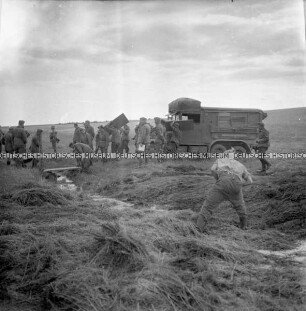 Deutsche Soldaten helfen LKW der Wehrmacht durch sumpfiges Gelände
