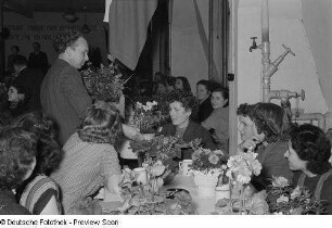 Übergabe von Blumengeschenken auf einer Veranstaltung zum Internationalen Frauentag