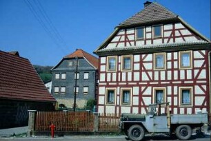 zwei Wohnhäuser mit Krüppelwalmdach; vorn Sichtfachwerk, hinten verschieferter Giebel