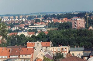 Blick vom Dach des Kaufhauses Nickel Richtung Nordosten auf Wohn- und Geschäftshäuser an Lübecker Straße und Pferdemarkt: hinten rechts Wohnblock am Berliner Ring: hinten links und Mitte Shell-Tankstelle und Mecedes-Benz-Autohandel an Segeberger Straße: dahinter Wohnhäuser am Wendum und Am Stadion: im Hintergrund Wiesen