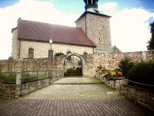 Ried-Ansicht von Südsüdwesten mit Kirche (Kirchturm Spätgotisch auf Vorgänger-Langhaus Neubau 1933) über Kirchhofmauer (Wehrgang im 18 Jh abgetragen) und erhaltenem äußerem Torbogen