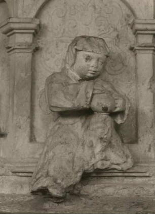 Döbeln, Nicolaikirche, Taufstein, Detail des Reliefs : Kind mit Henkelkrug, Stichbogenöffnung im Unterbau, 1603, Sandstein