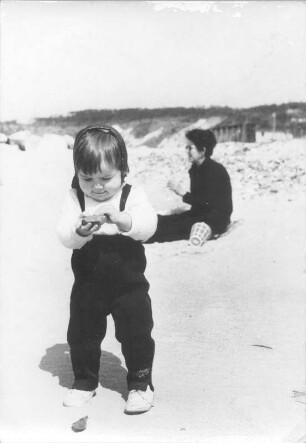 Kleines Mädchen beim Steinesammeln am Strand von Hiddensee
