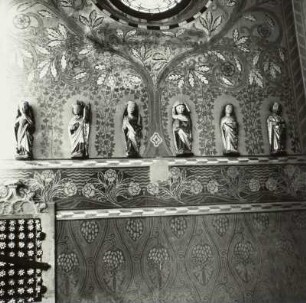 Heiligenfiguren vor Wandmalereien