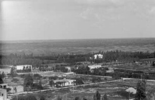 Siedlung : Blick über eine Ebene mit Feldern und Gebäuden