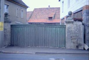 Hofzufahrt mit niedrigem Holztor, Torpfeiler mit Bekrönungssteinen in Kugelform