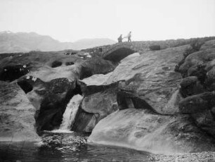 Brücke : Eine Brücke über einen kleinen Wasserfall zwischen Felsen