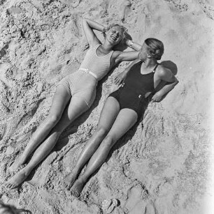 Zwei Frauen in Bademode liegen am Strand