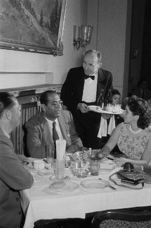 Der Kellner des Parkhotels Erich Bergner serviert dem Vertreter des indischen Rates für Außenhandel namens Rao und weiteren Personen Getränke