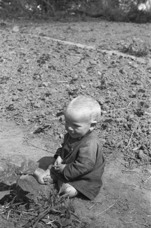 Zweiter Weltkrieg. Zur Einquartierung. Sowjetunion. Kleinkind, am Feldrand sitzend
