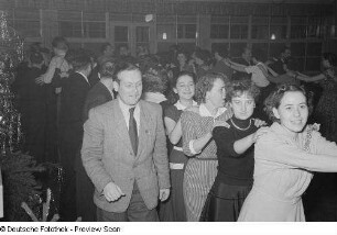 Gäste einer Betriebsweihnachtsfeier beim Tanzen einer Polonaise