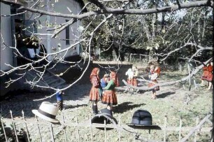Huta Certeze: Trachten vor der Kirche, Hüte auf Zaun