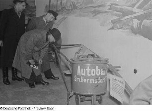 Ausstellungsbesucher vor dem Exponat "Rasenkantenschneider für die Autobahnen"
