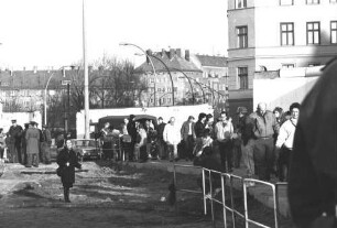 Menschengruppe vor einem provisorischen Grenzübergang in der Schwedter Straße