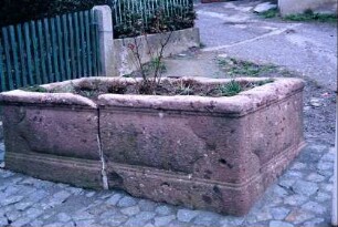 zerbrochener Laufbrunnen, jetzt Blumenrabatte