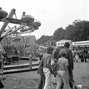 Schützenfest: Veranstalter Bürgerschützengilde von 1627 e.V. Bad Oldesloe: Volksfestplatz auf Exer: Karussell in Fahrt, Jahrmarktstände: Besucher, im Vordergrund Kinder, 25. Juli 1976