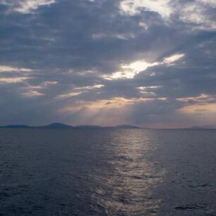 Tinos. Abendliche Silhouettenblicke auf Delos und Mykonos. Rechts Tinos