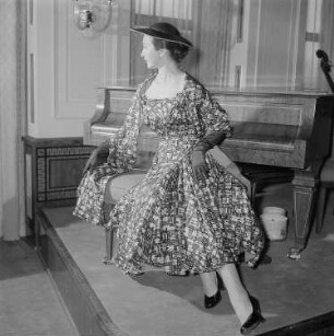 Messemodenschau, Frau im Kleid vor einem Klavier