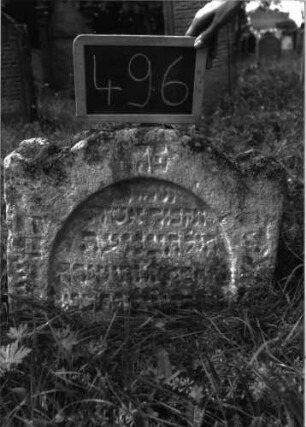 Grabstein 496 (Index: 100102636) Material: Sandstein Zustand: stark verwittert, eingesunken, weitgehender Textverlust Maße HxBxT: 49x59x10 cm Beschreibung: Stele, eingezogener Rundbogenabschluss, Einzüge erhöht, Schriftfeld eingetieft mit Rundbogenabschluss: Grabstein 496