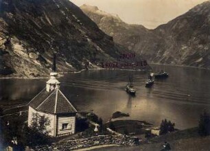Merok/Norwegen. Blick auf die Bucht von Merok mit Kirche, im Hintergrund mehrere Passagierdampfer