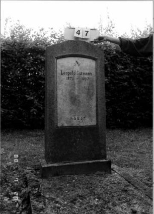 Grabstein 47 (Index: 100110140) Material: Sandstein, weiße Marmorplatte Zustand: mehrfach gesprungen Maße HxBxT: 142x59x15 cm Beschreibung: Stele, Sockel, giebelartiger, abgeflachter Abschluß, Schriftplatte mit Segmentbogenabschluß: Grabstein 47