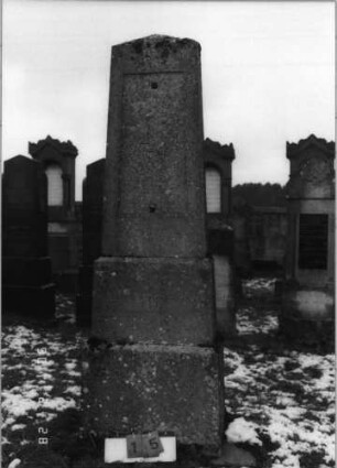 Grabstein 15 (Index: 100114966) Zustand: Texttafel fehlt Maße HxBxT: 219x69x39 cm Beschreibung: Obelisk auf gestuftem Sockel, vertiefter Textteil, eingesetzte Texttafel: Grabstein 15