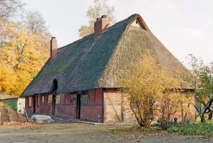 Nütschau: Schloßstraße 42a-c: traufständige Mehrfamilienkate aus Fachwerk mit Reetdach: Straßenfront mit Eingangstüren, Sprossenfenster, Heuluke: Giebelseite, oben Eulenloch: links Erdhaufen, Baumaterial, hinten links Schuppen