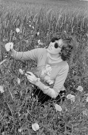 Renate Rössing in einem Kornfeld beim Pflücken eines Blumenstraußes