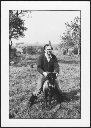 Der Schriftsteller Heinz Czechowski auf einem Schaf (Widder ?) sitzend, aufgenommen in Hochkirch-Wuischke