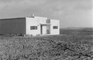 Siedlungshaus : Blick auf ein Gebäude in einer ebenen Landschaft