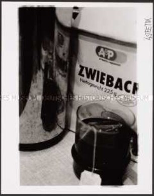 Teeglas und Zwiebackpackung (Sonderthema: Essen und Trinken)