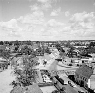 Vogelperspektive: von Silo der Weizenmühle ("Gloria-Mühle") der Johannes Ströh Mühlenwerke am Pferdemarkt: Blick nach Nordosten: vorne Straße Pferdemarkt mit Kopfsteinpflaster, Pkws, Lkw, Gaststätte "Stadt Kiel", Parkplatz, Hecken, Bäumchen mit Kugelschnitt, alter Baum: Mitte Kreuzung, links Pferdemarkt, rechts Berliner Ring, nach hinten Segeberger Straße mit Kopfsteinpflaster: rechts Shell-Tankstelle, Mercedes-Autowerkstatt: hinten links Häuser an Straße Am Stadion