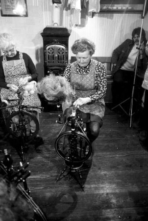 Frauen beim Flachsspinnen in Wohnstube