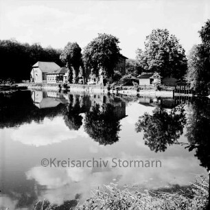 Lasbek-Gut: Lasbeker Mühle und Mühlenteich mit Bäumen: Spiegelung im Wasser