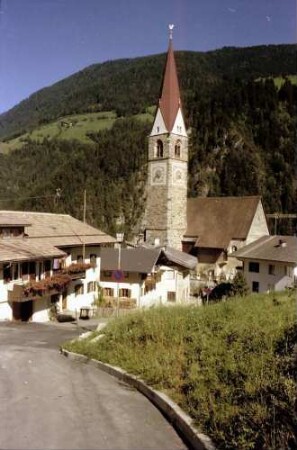 St. Pankraz: Spitzer Kirchturm zwischen Dächern, mit ganzer Ortschaft