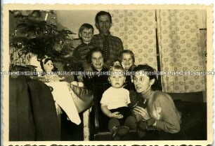 Familie mit vier Kindern am Weihnachtsbaum