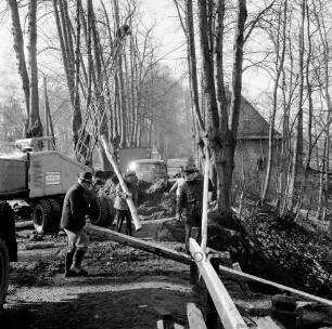 Brücke des Mühlenredder über dem Abfluss des Schlossgrabens: Renovierung: Blick Richtung Westen: Arbeiter beim Aufbau von Gerüst: Baukran, Lkw, Bauwagen: rechts Schlossmühle