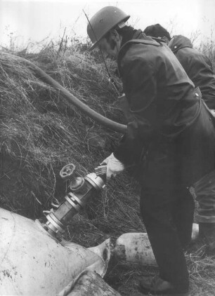 Feuerwehrleute beim Befüllen eines Sperrschlauches mit Wasser zum Schutz vor Hochwasser