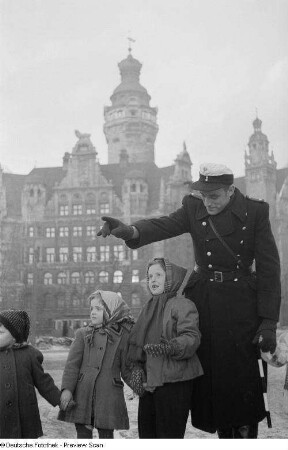 Ein Verkehrspolizist führt eine Gruppe von Kindern über die Straße