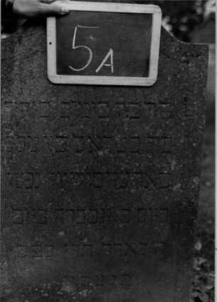 Grabstein 5 (Index: 100111013) Material: Sandstein Zustand: leicht verwittert Maße HxBxT: 85x55x10 cm Beschreibung: Stele, Konvexbogenabschluß, Schriftfeld eingetieft Besonderheit: Kindergrab: Grabstein 5A