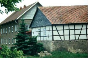 renoviertes Fachwerkgebäude, dahinter Wohnhaus