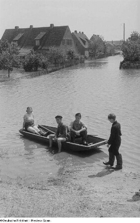 Blick auf Menschen in einem Boot auf einer überschwemmten Straße